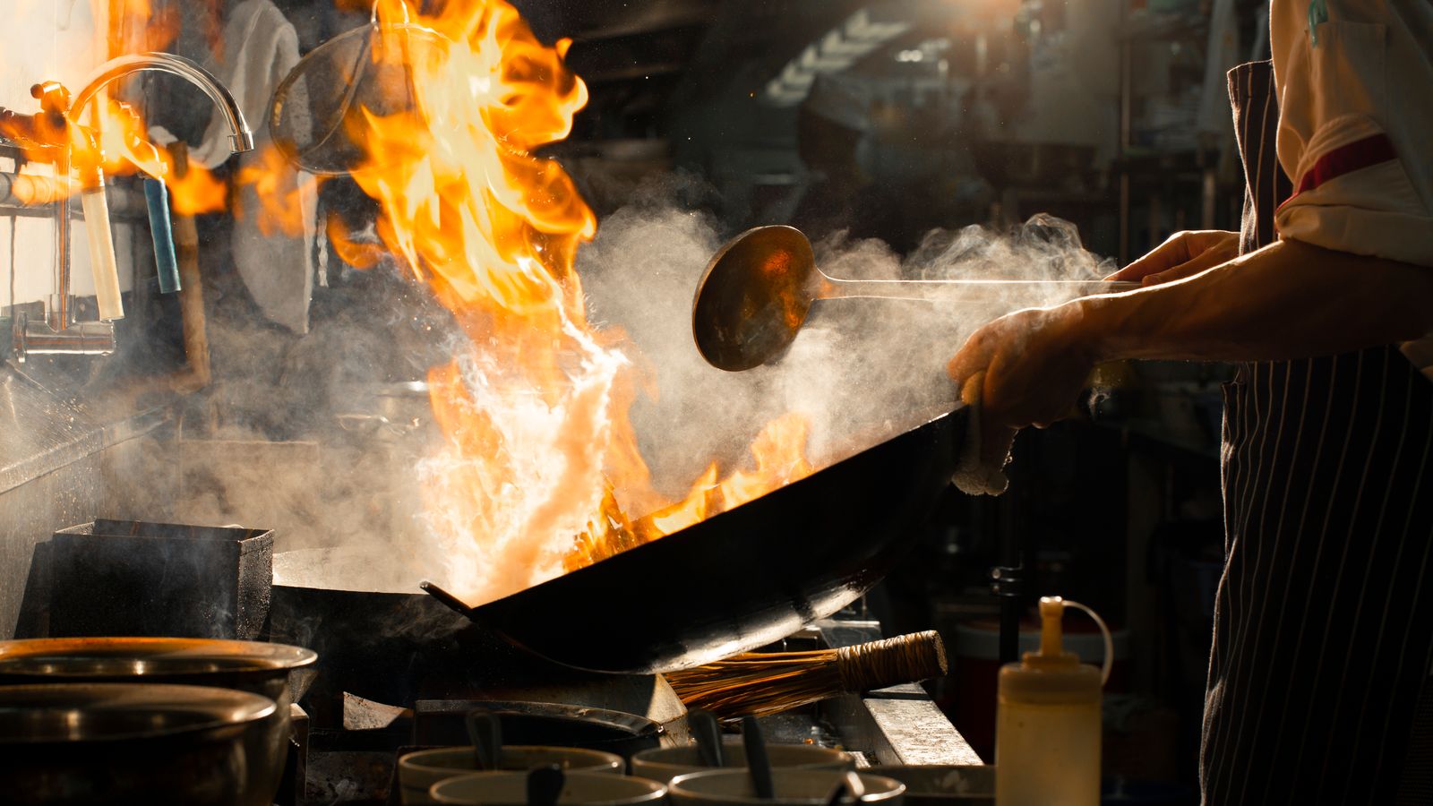 Koch bei der Arbeit an einer Großküchen-Flamme